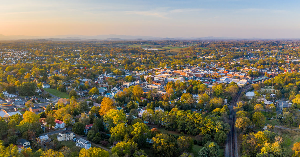 aerial photo trees, houses and buildings in culpeper with mountains in background