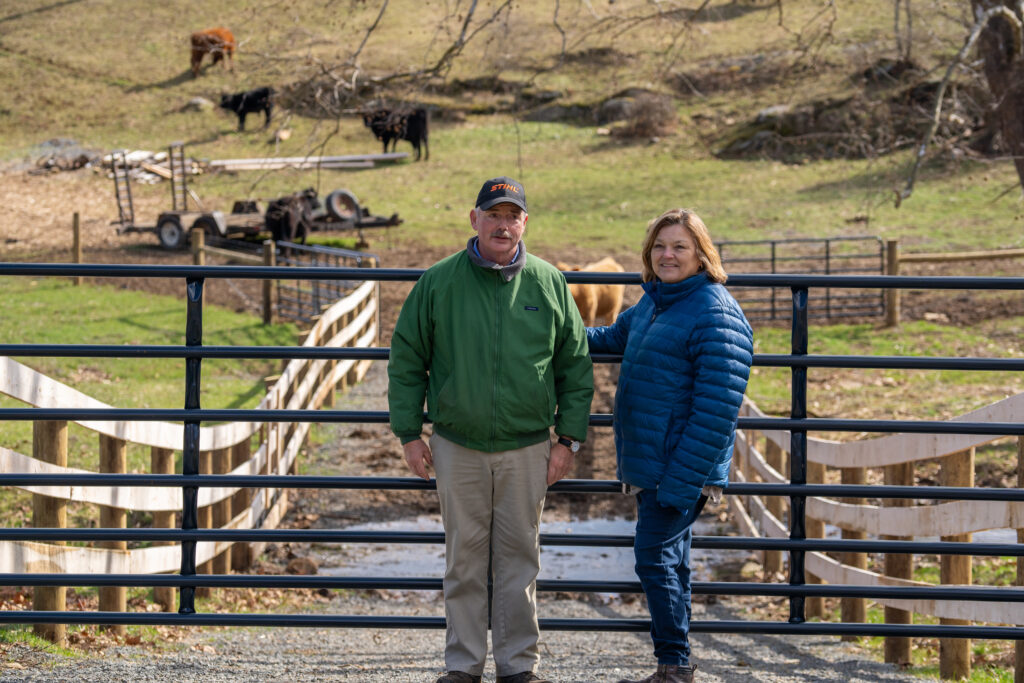 Dean and Carina Elgin stand in front of livestock exclusion fencing on their farm.